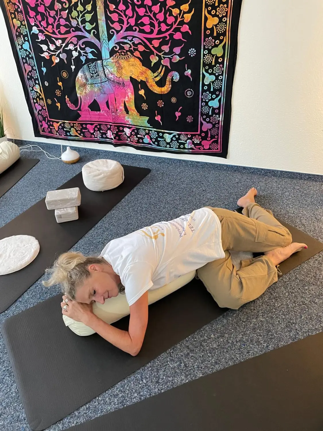 Vitalelebensweise - Martina Ernst, Frau auf Yogamatte liegend